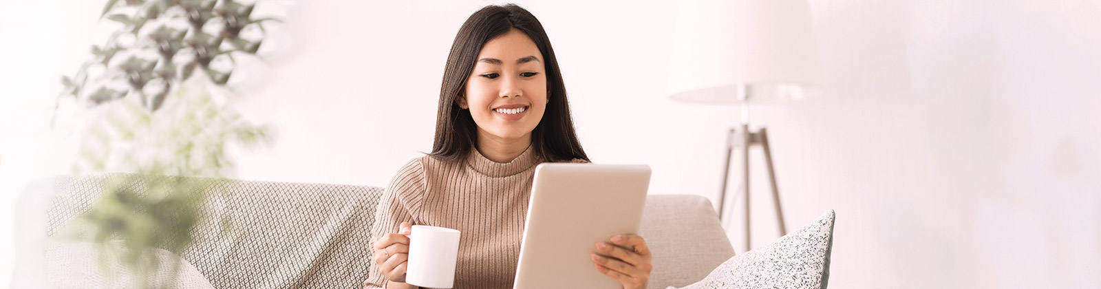 Girl with Mug Looking at Tablet